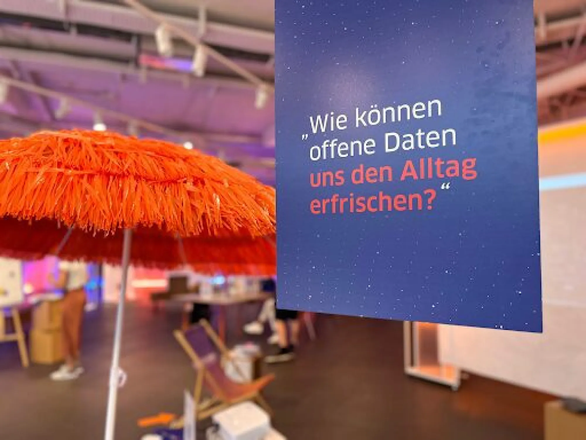 Schild mit Open Data Beschriftung vor einem orangenen Sonnenschirm